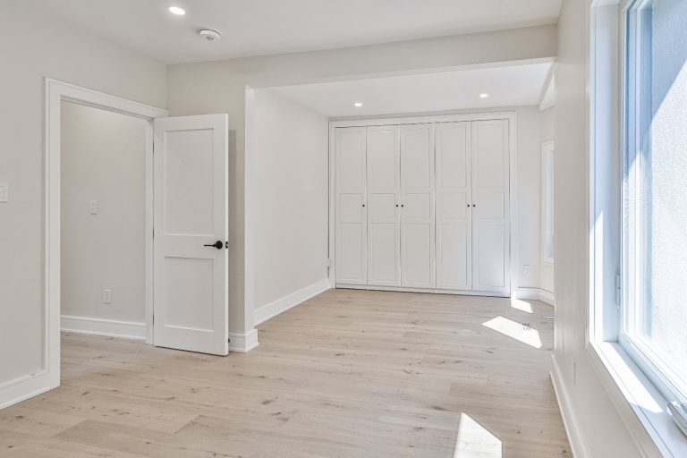 large bedroom with built-in closet and hardwood floor